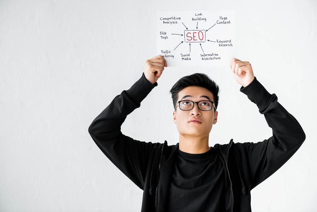 asian seo manager holding and looking at paper with concept words of seo